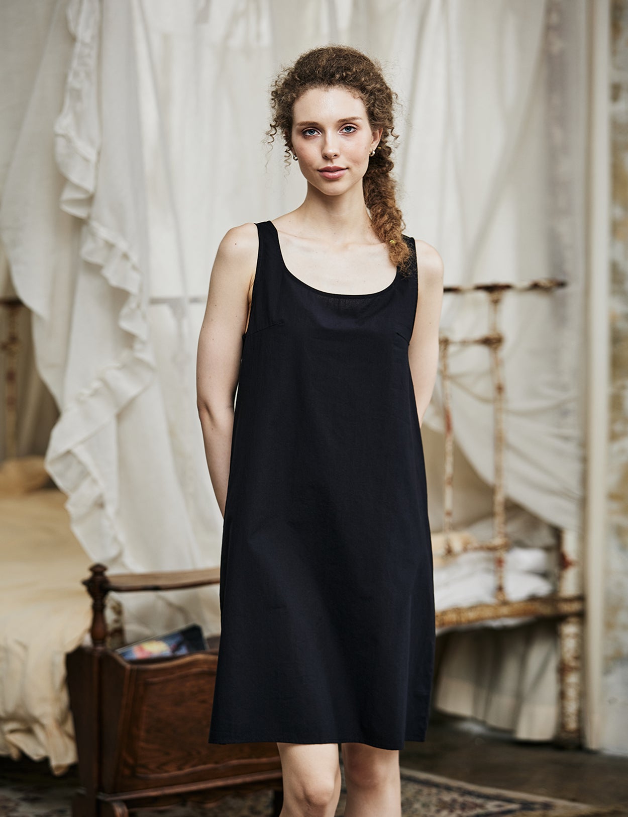 Women's black cotton full slip with wide straps, showing modesty panel and knee-length design
