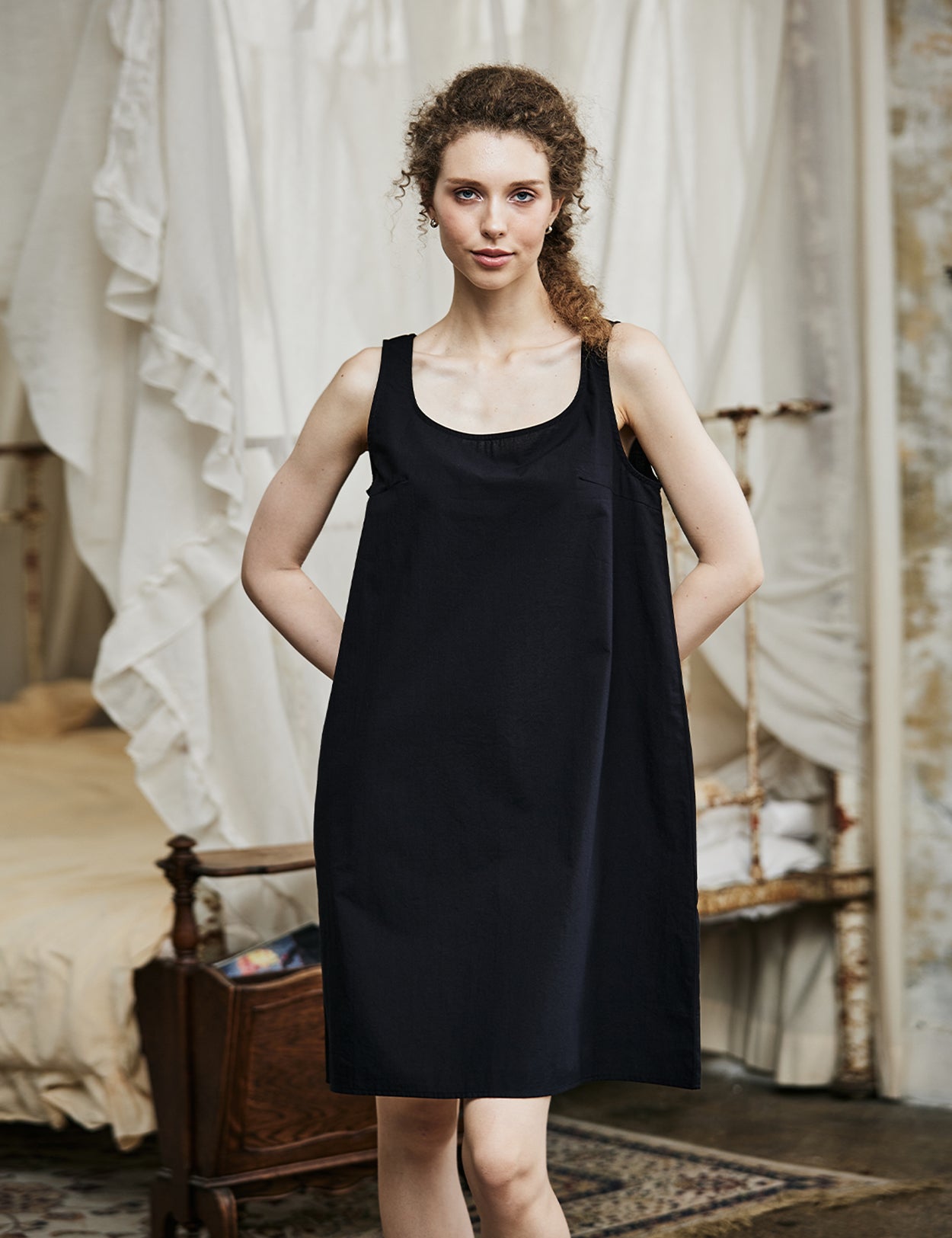 Women's black cotton full slip with wide straps, showing modesty panel and knee-length design