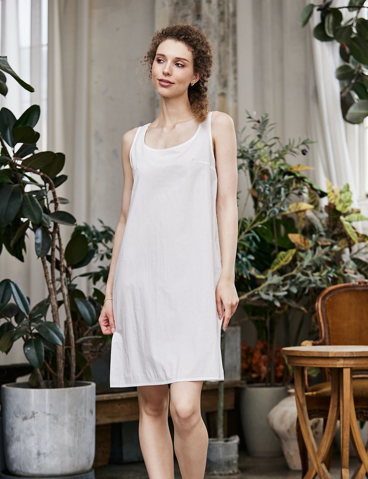 Women's white cotton full slip with wide straps, showing modesty panel and knee-length design