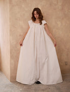 Sueasyretro floor-length ivory Victorian nightgown. Woman holding the voluminous 100% cotton skirt with lace hemline.