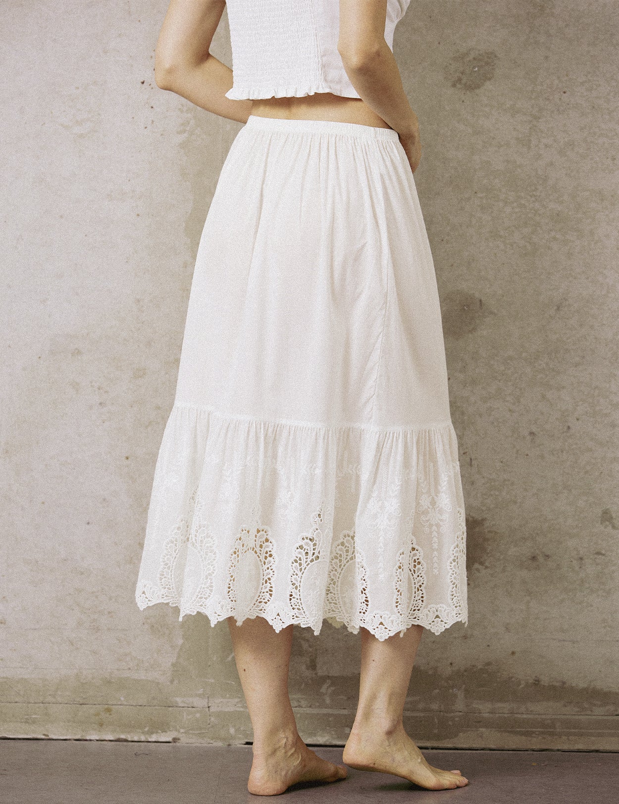 Back view of the mid-length white cotton half slip, showing the breathable fabric and ruffled lace hem design.