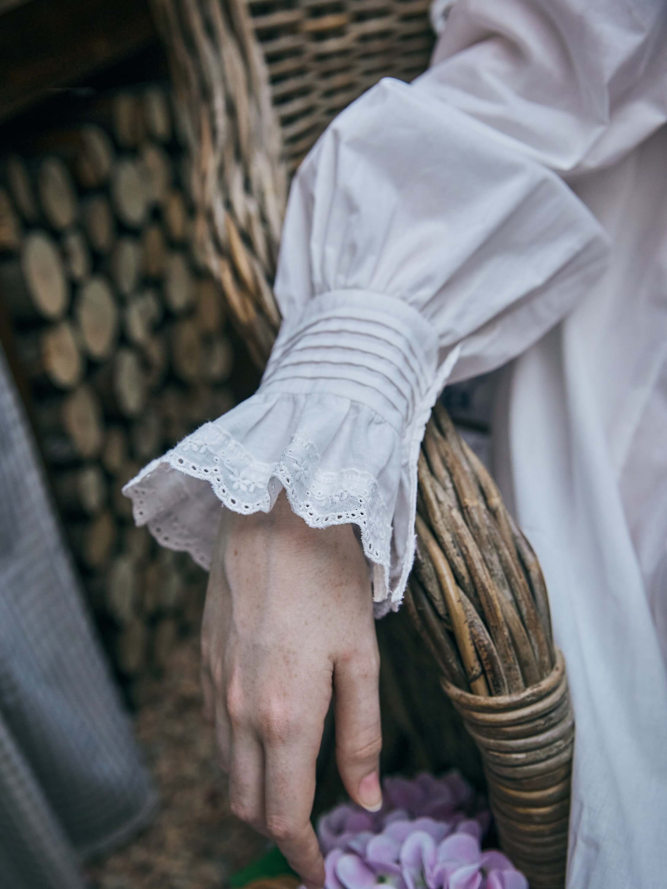 Detail shot of the long bishop sleeves featuring elongated cuffs with intricate pintucks and dainty lace trim on a vintage style white nightdress.