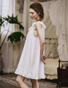 Side profile of the short cotton sleep dress featuring delicate Broderie Anglaise embroidery and a loose, comfortable fit.