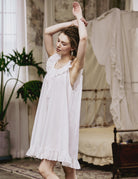 Side profile of the short cotton sleep dress featuring delicate Broderie Anglaise embroidery and a loose, comfortable fit.