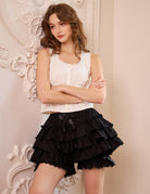 Close-up of woman wearing black cotton bloomers and cropped lace camisole, front view