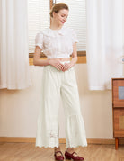Woman wearing Sueasyretro cream vintage bloomer pants in 100% cotton for a relaxed, romantic look.