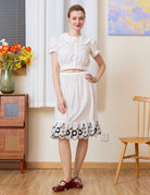 Tudor-Inspired Half Slip: full front view of cotton skirt extender with black floral hem styled in a retro room.