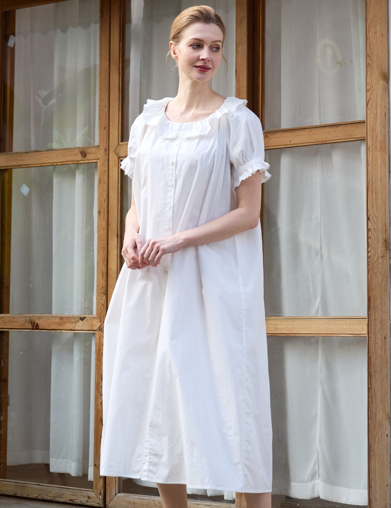 Medium shot of a white Sueasyretro retro house dress with front buttons.