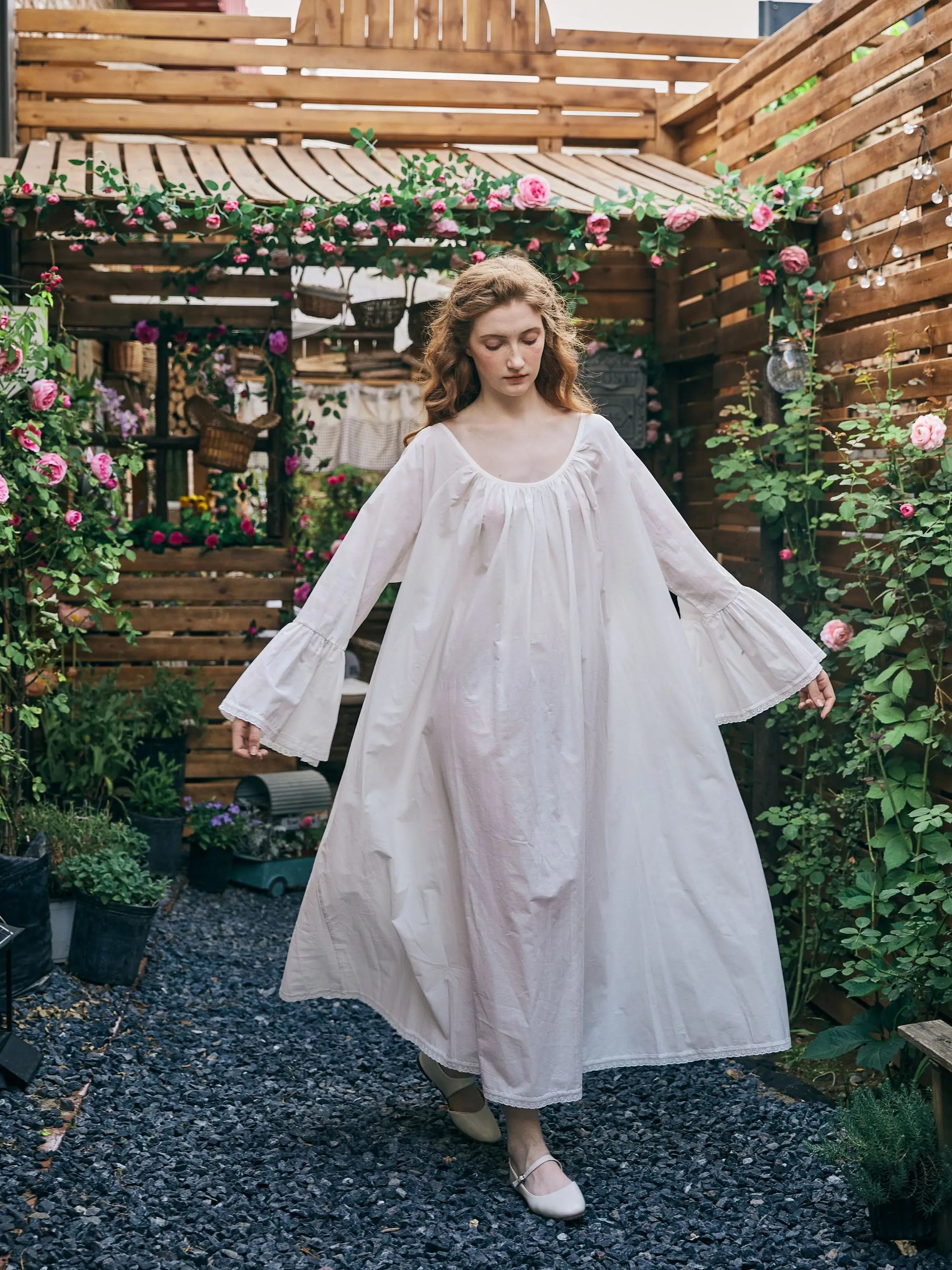 Full-length view of Victorian cotton nightdress with wide bell sleeves and flowing hemline.