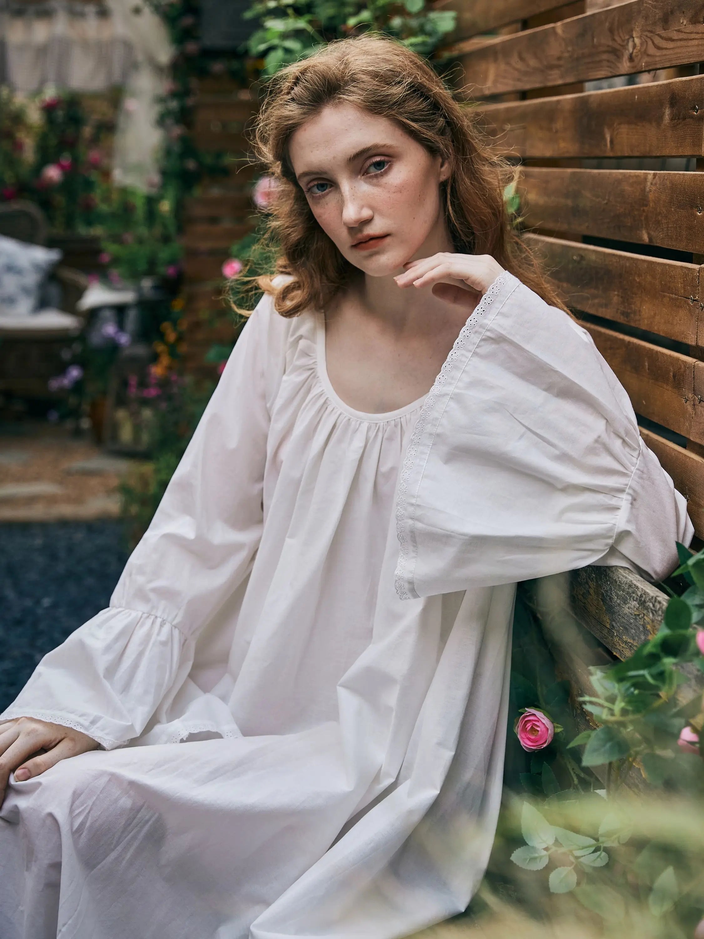 Close-up of Victorian cotton nightgown featuring gathered neckline and bell sleeve details.