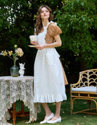 Full-length view of ivory Victorian cotton pinafore apron with ruffle hem