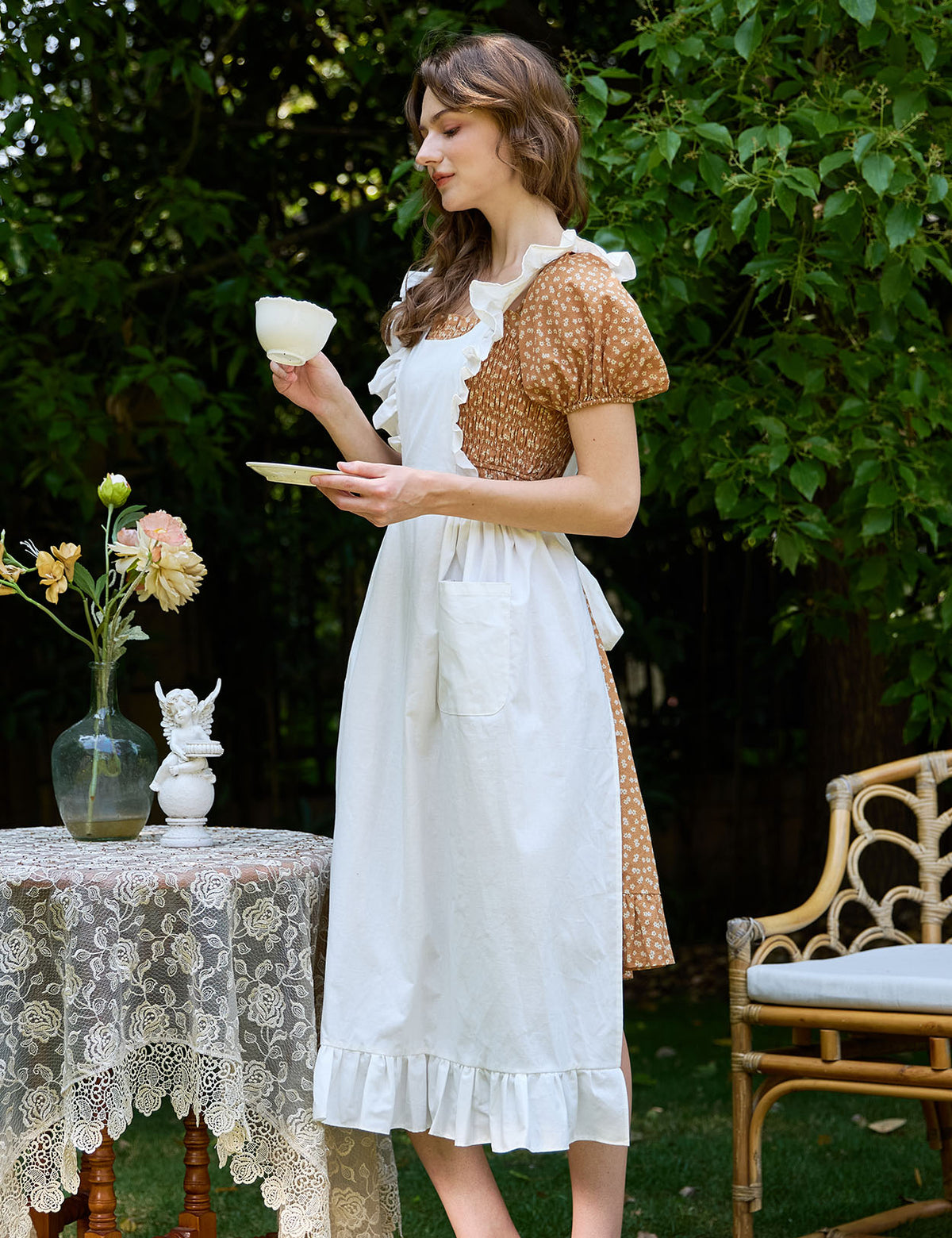 Woman wearing Victorian cotton pinafore apron at afternoon tea party