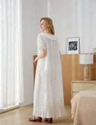Back view of a woman modeling a flowing vintage-style cotton nightdress, showcasing the relaxed A-line fit and Broderie Anglaise ruffled hem