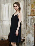 Women's black cotton full slip with spaghetti straps, showing comfortable fit and classic design