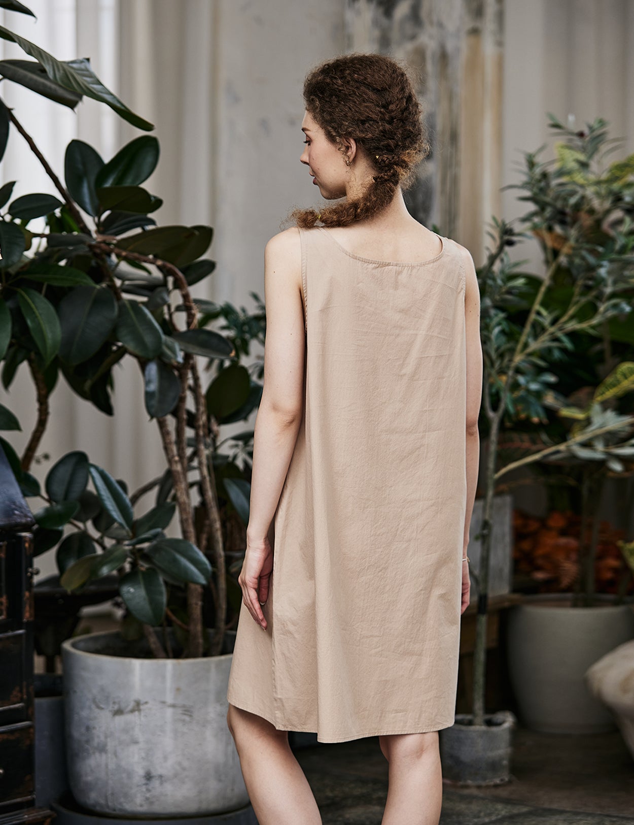 Women's nude cotton full slip with wide straps, showing modesty panel and knee-length design - back view