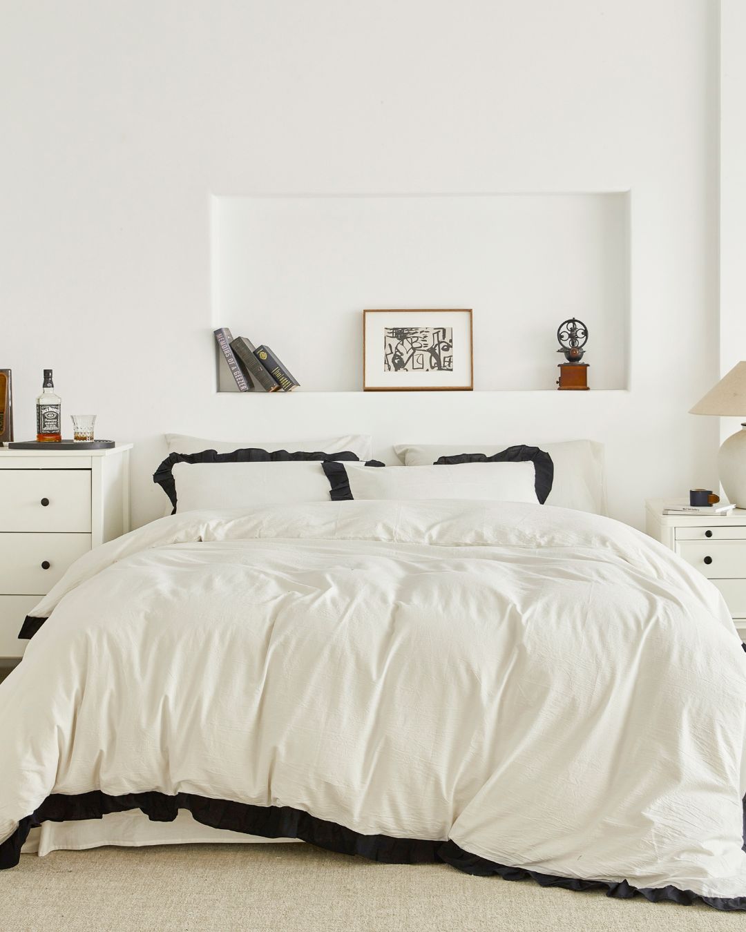 Full view of vintage white washed cotton duvet cover set with black ruffle trim styled in a minimalist bedroom