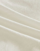 Close up texture view of soft white washed cotton fabric showing natural wrinkles and breathable quality