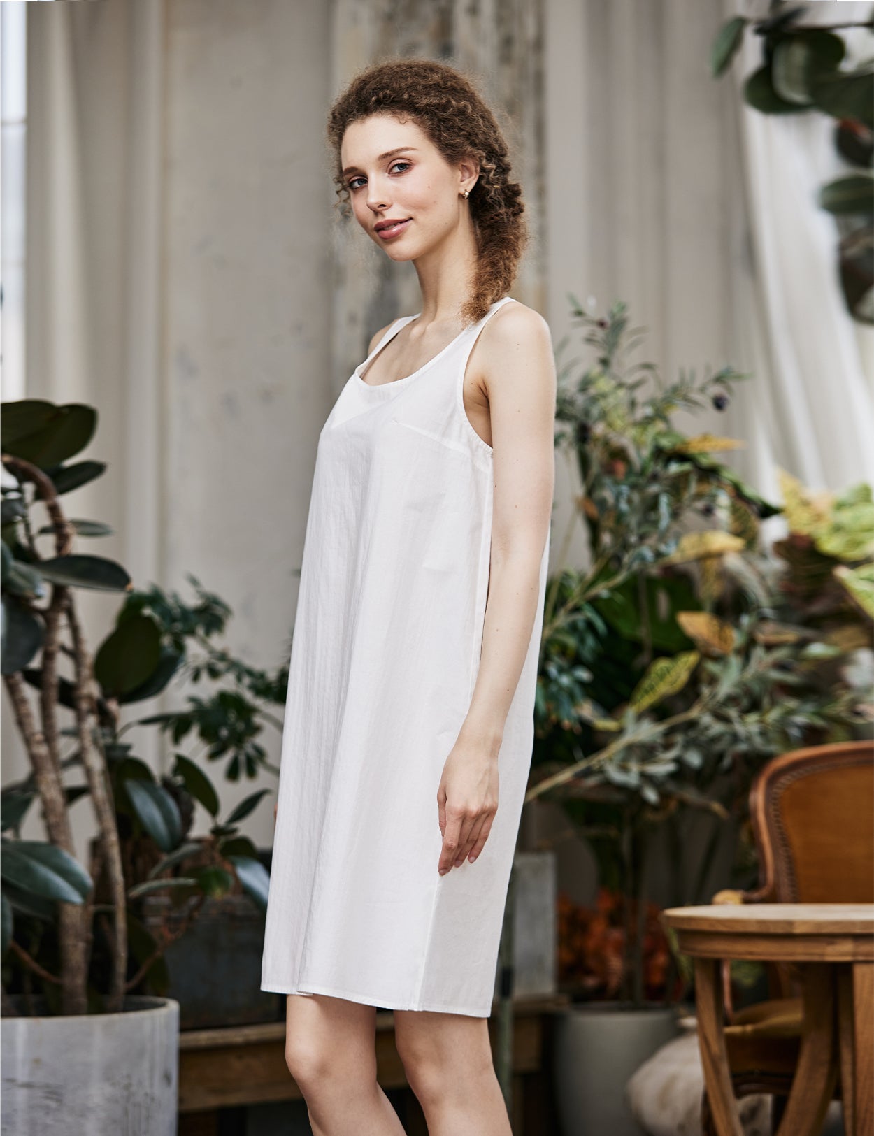 Women's white cotton full slip with wide straps, showing modesty panel and knee-length design