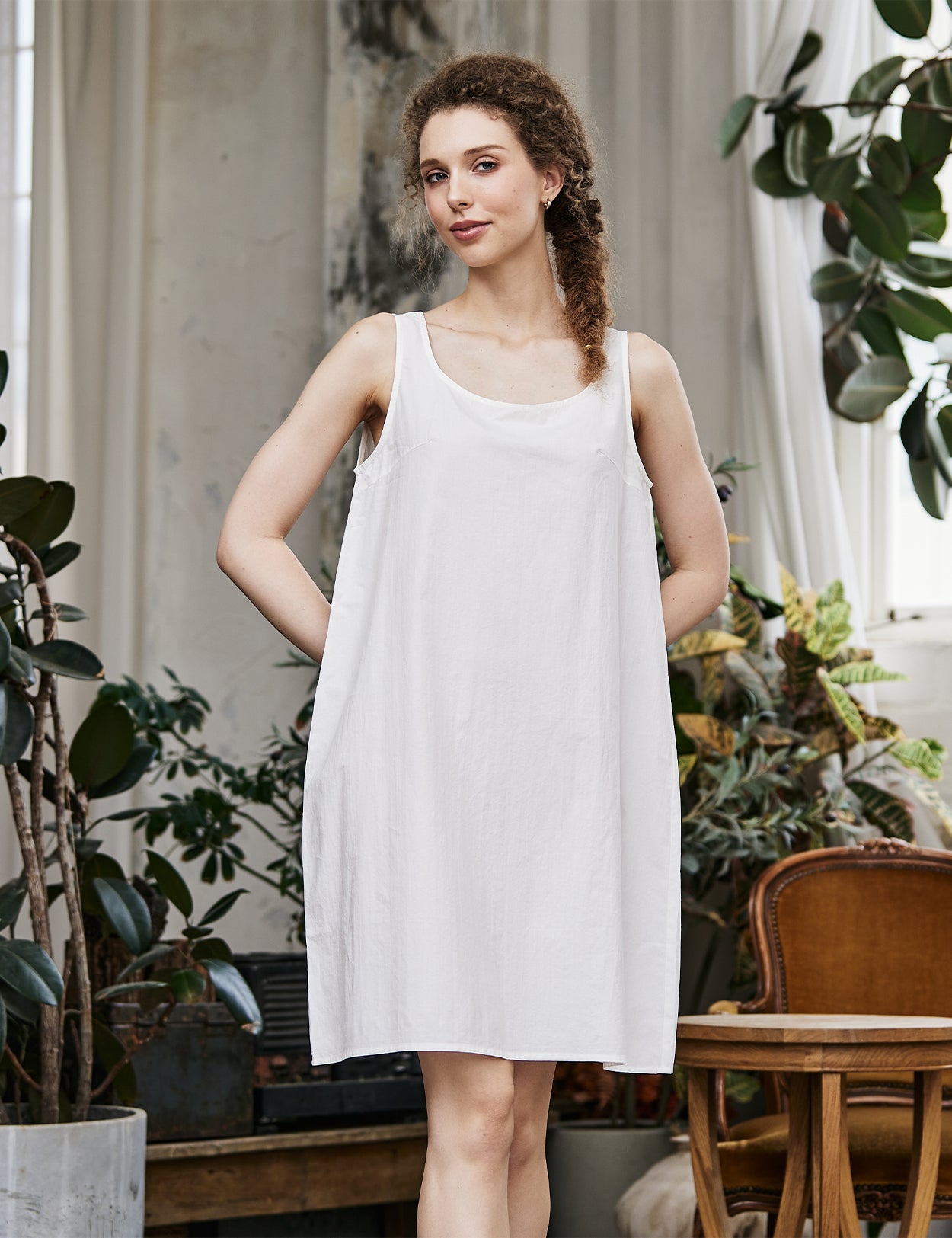 Women's white cotton full slip with wide straps, front view showing modesty panel and knee-length design