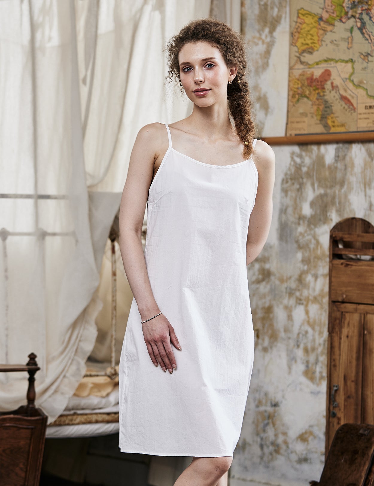 Women's white cotton full slip with spaghetti straps, showing comfortable fit and classic design